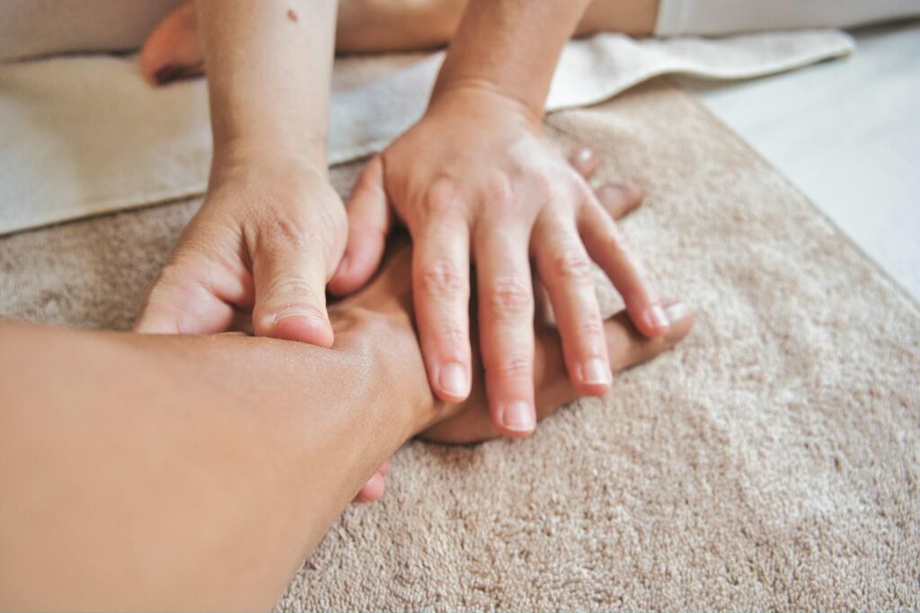 A pair of hands is massaging another person's hand