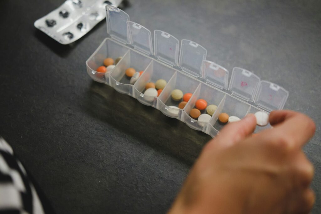 A pill organizer is open with various pills inside.