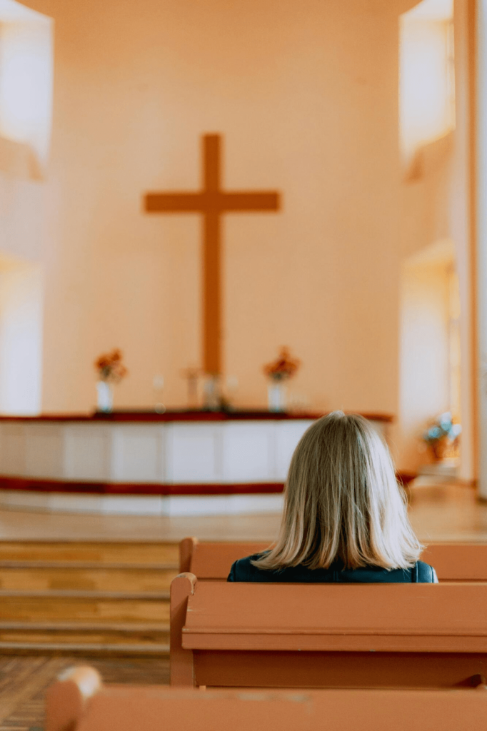 A lady sits in a church.